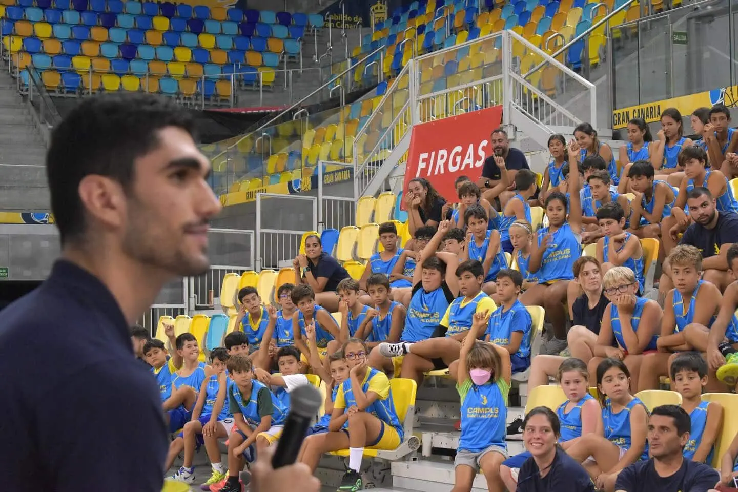 Santi Aldama dirigiéndose a los alumnos del campus en una charla sobre desarrollo personal y valores deportivos en el Gran Canaria Arena